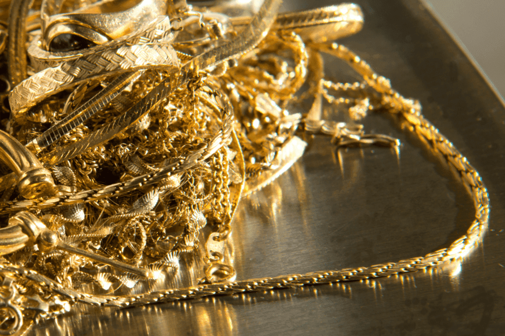 A cluster of tangled gold chains on a polished silver tray.