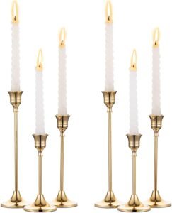 Two sets of six brass gold metal taper candle holders with a sleek, elegant design, showcasing varying heights to create a sophisticated and timeless look.