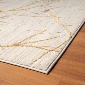 Modern abstract area rug with a cream base and metallic gold accents, featuring a tree branch-like design, placed in a stylish living room with wooden floors. #1