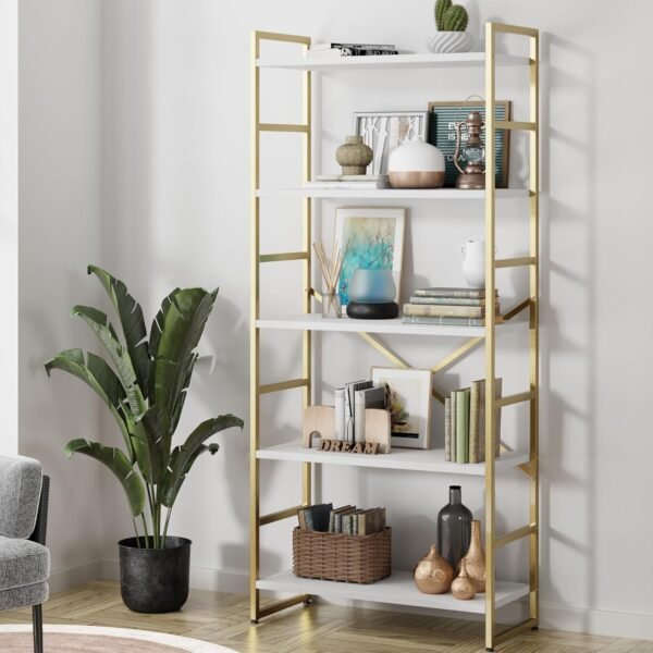 Modern gold bookshelf with five white shelves, displaying books, decor items, and plants, placed in a stylish living room with natural light.