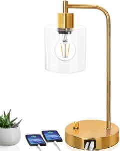 Gold industrial table lamp featuring a clear glass shade, modern design, and two USB ports for convenient device charging, paired with a sleek gold base