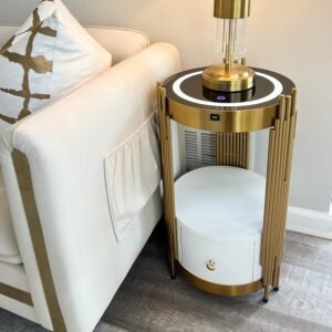 A chic gold accent table featuring a modern cylindrical design with vertical golden bars, a white drawer with a gold knob, and a polished gold base. Perfect for adding elegance and functionality to any living space.