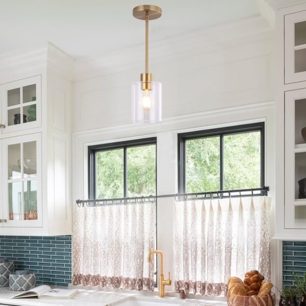 Set of two gold pendant light fixtures with brass finish and clear glass shades, featuring adjustable rods for modern kitchen or bar lighting. A Lovely accent for the kitchen.